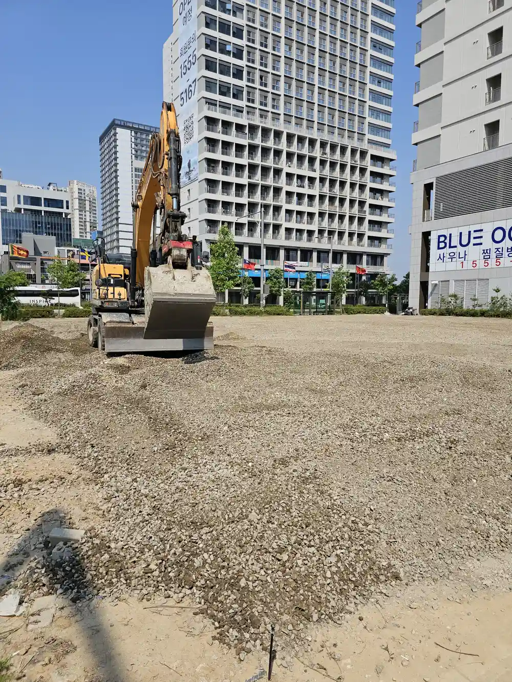 굴착기 부착 장비로 포설된 골재를 고르고 다지는 작업