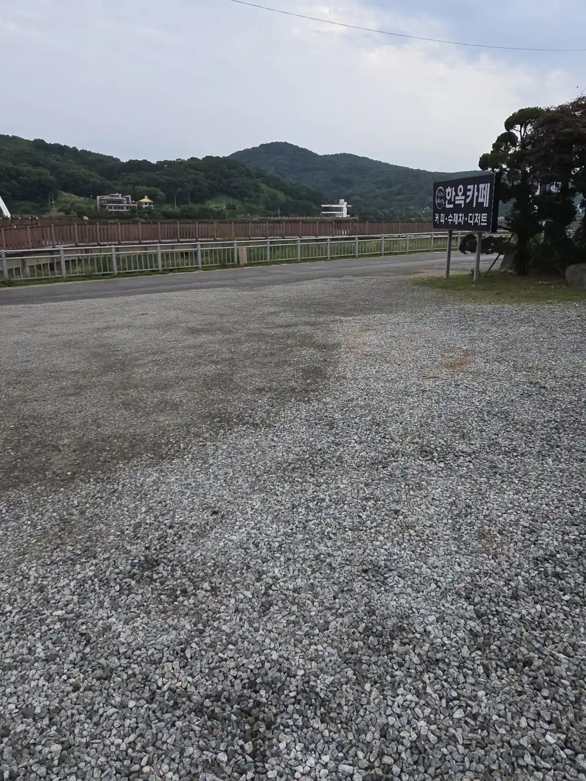 한옥카페 간판이 보이는 도로 인접 자갈 구역