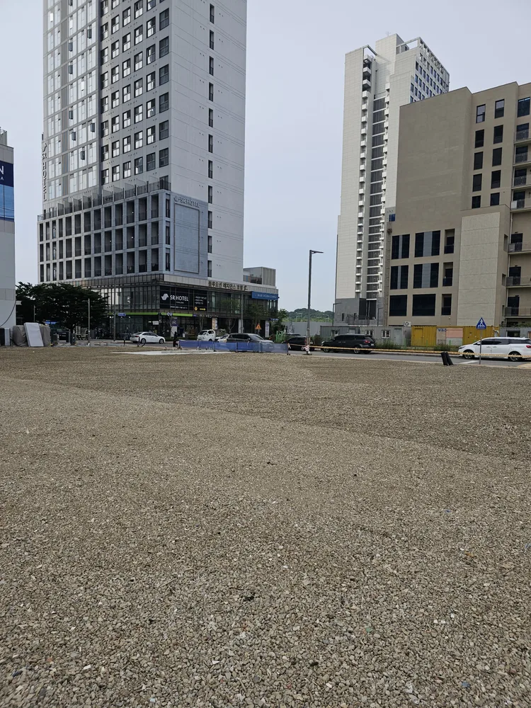 골재가 고르게 포설되어 주차 공간이 된 신도시 부지