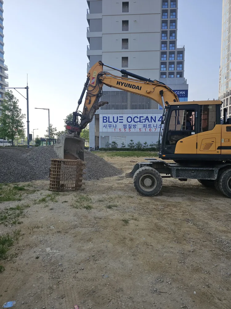 굴착기와 경계석 자재가 현장에 반입된 유휴부지 주차장 조성 작업 모습