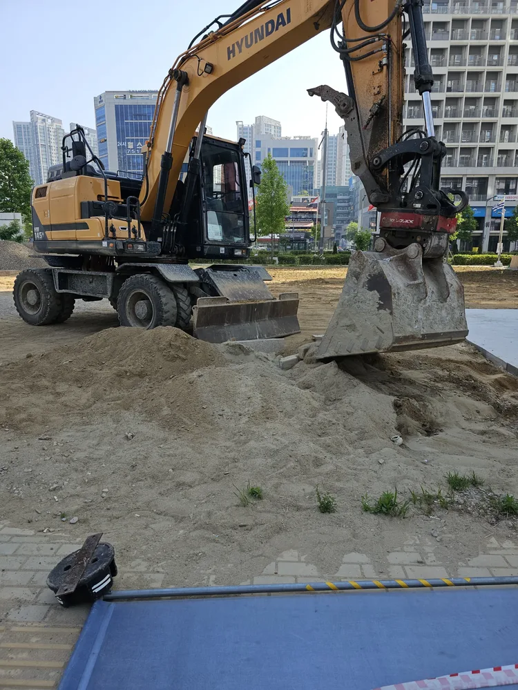 골재 포설과 다짐이 진행 중인 맨땅 주차장 현장